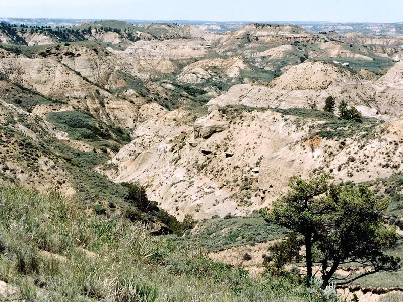 Pale, eroded badlands under a blue sky in Montana